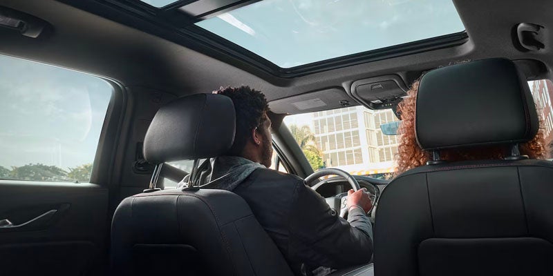 Man driving a Chevrolet Blazer with the sunroof, enjoying the sleek, modern interior.