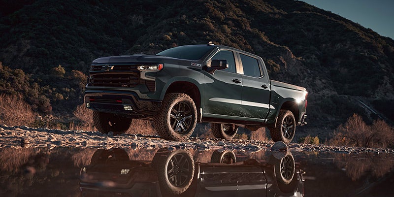 Chevrolet Silverado 1500 with a mountain and pond reflection.