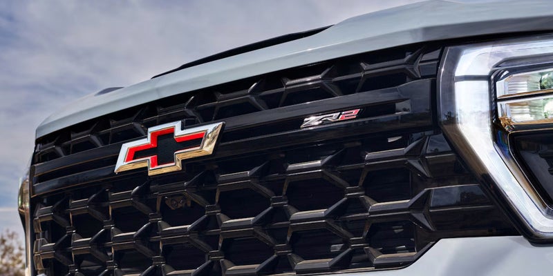 Dark grey Chevy Silverado off-roading, kicking up dirt.