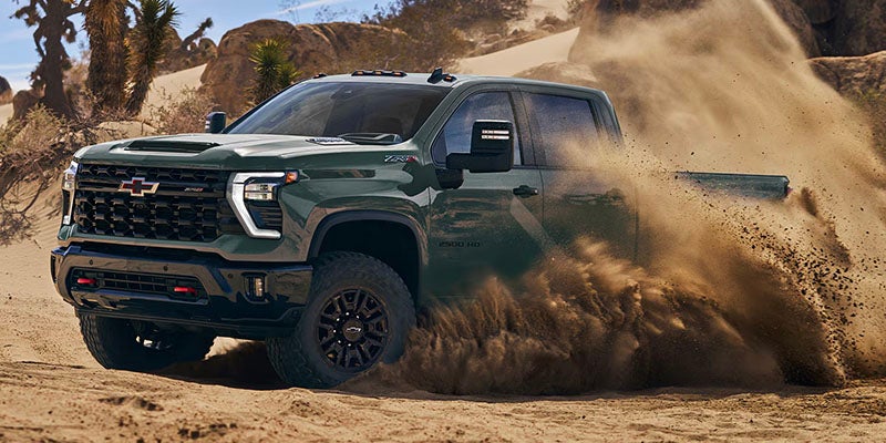 Dark green Chevrolet Silverado driving through desert sand